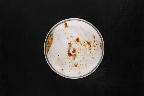 Beyaz bir arka plan üzerinde siyah bir taş tabak üzerinde bir kavanozda Bal cheesecake tatlı