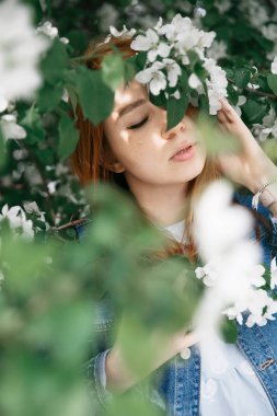 Güzel kızıl saçlı kız poz ve baharda bir elma renklerde rüya