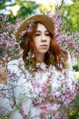 Güzel kızıl saçlı kız poz ve bahar badem çiçekleri rüya
