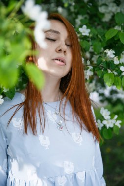 Güzel kızıl saçlı kız poz ve baharda bir elma renklerde rüya