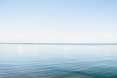Sakin su ve berrak gökyüzü ile bir yaz akşamında gün batımında