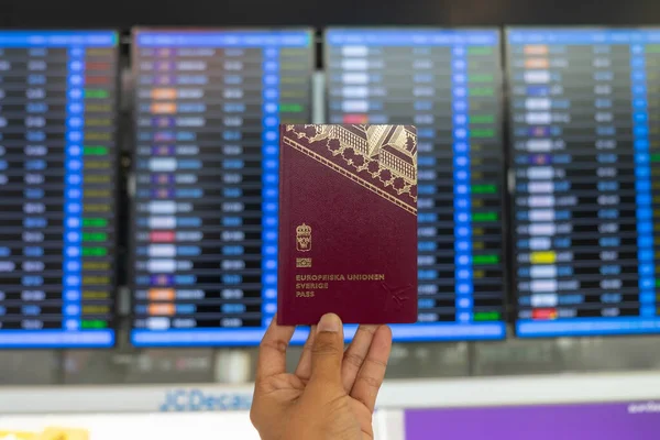 Libro Pasaportes Mano Suecia Con Pantalla Información Vuelo Borrosa Aeropuerto — Foto de Stock