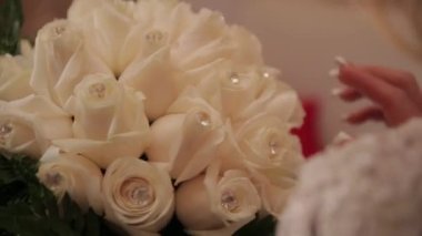 Gelin düğünde bir çiçek buketi tutuyor