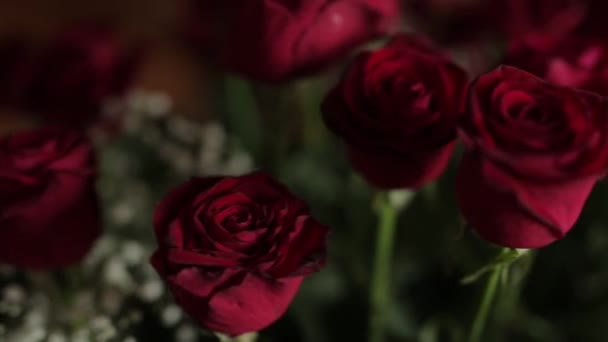 Anillos de boda en un ramo de rosas rojas, movimiento deslizante — Vídeo de stock