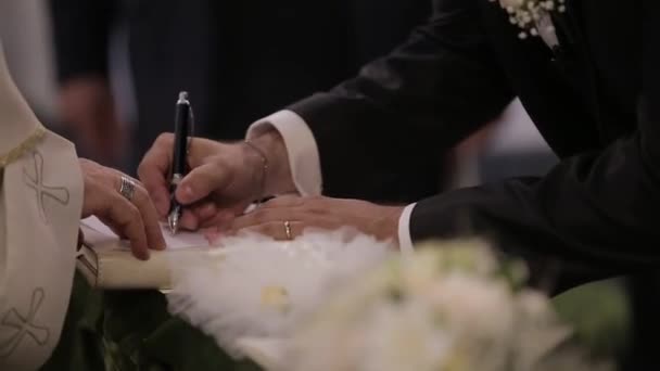 Wedding ceremony in the church, the bride and groom sign — Stock Video