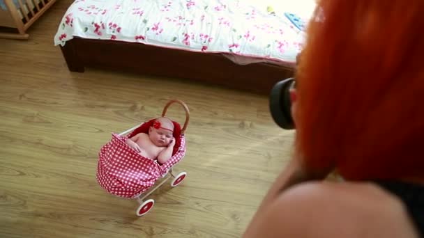 De fotograaf bereidt een pasgeboren meisje voor op een fotoshoot, verandert van kleding, verandert van achtergrond, verandert van houding — Stockvideo