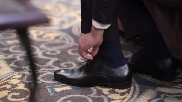 Wedding groom tie shoelaces on black shoes at home — Stock Video