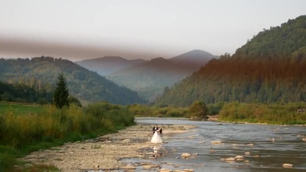 Noiva e noivo, o rio na montanha nos Cárpatos — Vídeo de Stock