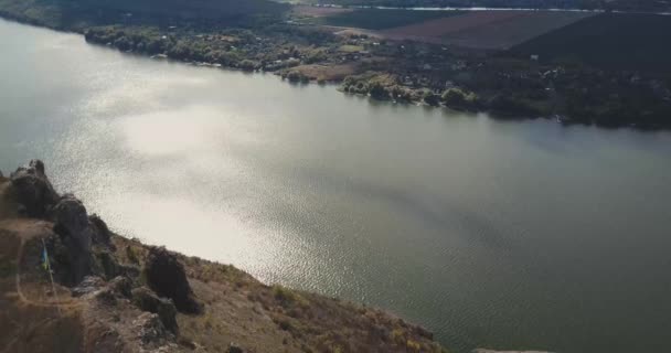 Noivo com uma noiva se beijando contra o fundo do rio Dniester, aero vídeo — Vídeo de Stock