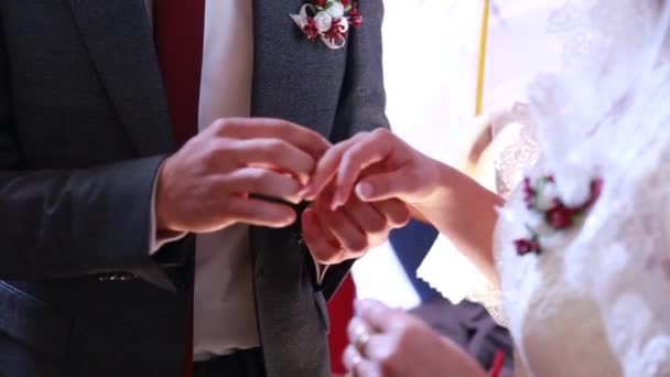 Close-up, cérémonie de mariage dans l'église, le marié avec l'échange habituel des alliances — Video