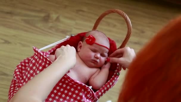 O fotógrafo prepara uma menina recém-nascida para uma sessão de fotos, muda de roupa, muda de planos de fundo — Vídeo de Stock
