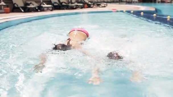 dospívající dívky plavání a potápění v bazénu a ukazují palec