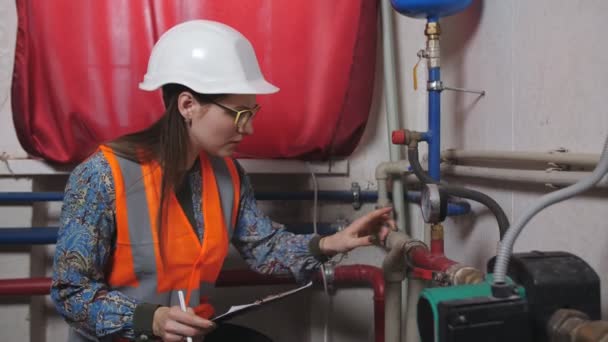 Woman engineer checks the meter readings in the boiler room. — Stock Footage Woman engineer checks the meter readings in the boiler room. Royalty Free Stock Footage