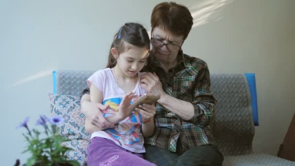 Malá vnučka učí svou babičku používat smartphone.