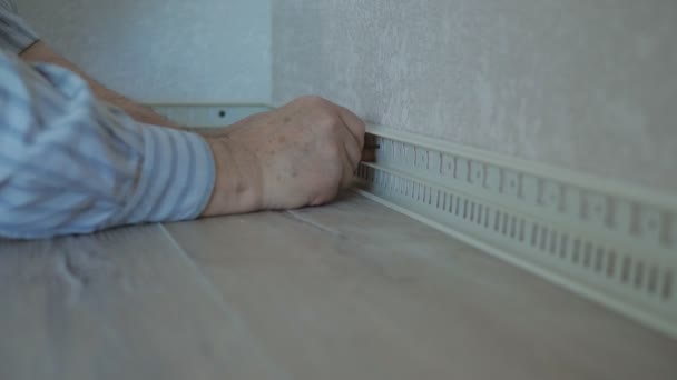 The master installs a floor skirting Board in the room. Close-up of the hands of the master fixing the skirting Board to the drywall. — Stock Footage The master installs a floor skirting Board in the room. Close-up of the hands of the master fixing the skirting Board to the drywall. Stock Video