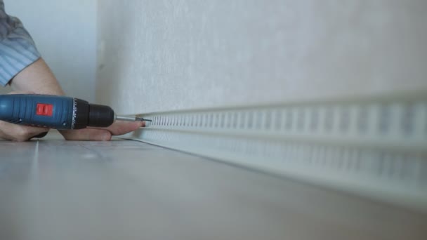 Then use a screwdriver to screw the screw into the drywall wall fixing the skirting Board. — Stock Footage Then use a screwdriver to screw the screw into the drywall wall fixing the skirting Board. Stock Video