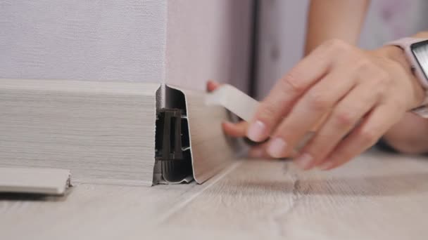 Technology of installation and installation of plastic floor plinth. Woman sets the outer corner on the baseboard — Stock Footage Technology of installation and installation of plastic floor plinth. Woman sets the outer corner on the baseboard Stock Video