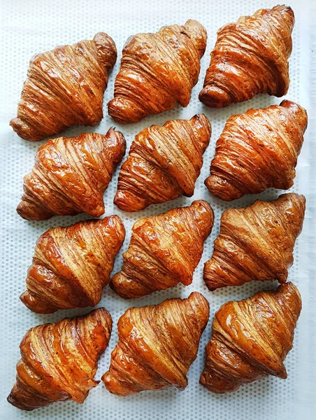 Flat lay composition with tasty croissants on patterned background. — Stock Photo, Image