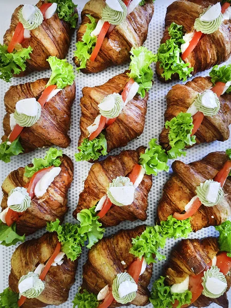 Sanduíches de pequeno-almoço com mini croissants, fatias de salmão defumado e salsa em fundo estampado. Croissants com peixe vermelho — Fotografia de Stock