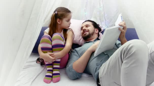 Little girl and her father reading a book together — Stock Video