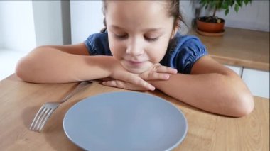 Pretty küçük kız mutfakta iştah ile onu spagetti makarna akşam yemeği yiyor