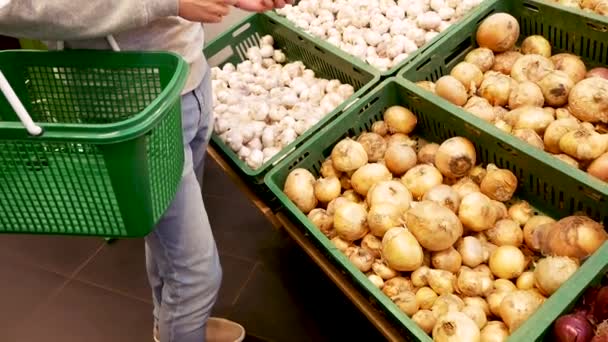 Jonge man handen kiezen van de groenten in de supermarkt en het zetten in de mand in de groente afdeling. — Stockvideo