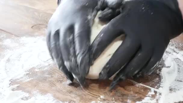 Fast food chef mains dans les gants déploie filo pâte feuilletée coupe rouleau, tarte ou gâteau sur une planche de bois. — Video