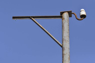 Eski paslı elektrikli sütun mavi gökyüzüne karşı