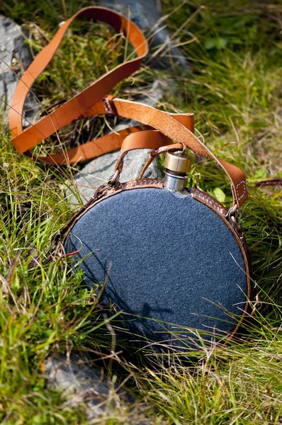 Yeşil çimlerde gri metal bir şişe.