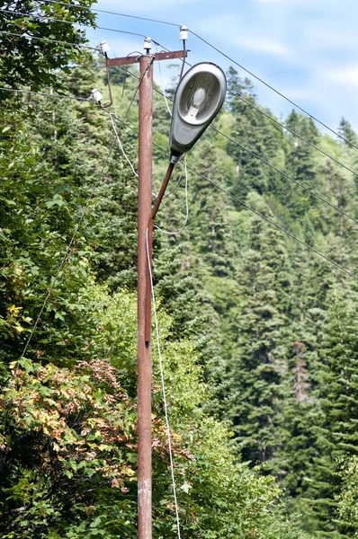 Dombay 'da fenerli eski, paslı bir elektrik direği.