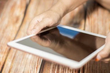 Modern dijital tablet kullanan kadın el, İPad 'e benzer. Kullanılan modern cihazlar kavramı. Bulanık alan derinliğine sahip yakın plan resim.