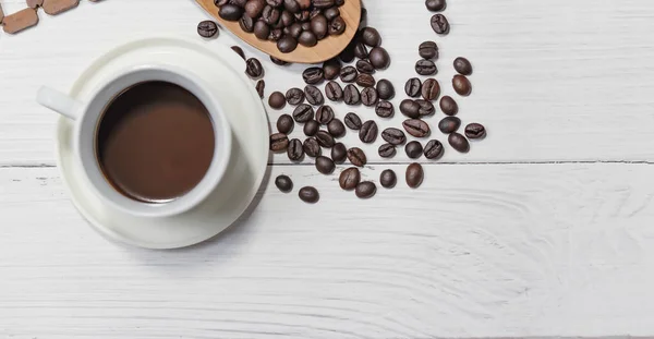 一杯黑咖啡和咖啡豆是白色木制背景的好东西 顶部视图 — 图库照片