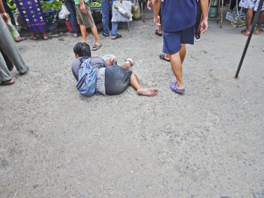 Sichon, Tayland-Aralık, 2016: bir dilenci sakat piyasada kaldırım yatıyor ve sadaka sorar