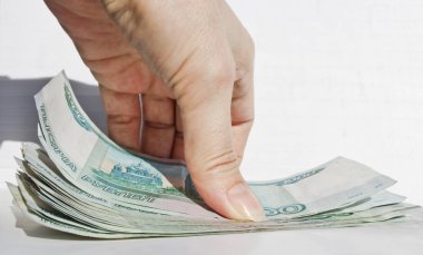 El tablo yüzeyinden 1000 Rublesi banknot bir paket alır..