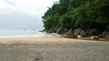 Deniz sörf dik kayalıklarla koy ve hafif kumlu bir plaj.