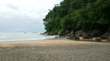 Deniz sörf dik kayalıklarla koy ve hafif kumlu bir plaj.