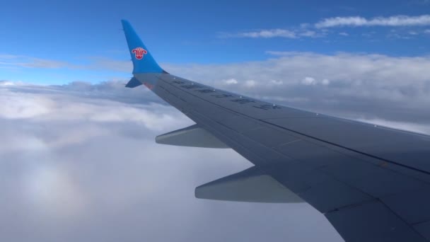 China Southern Havayolları uçak kümülüs bulutların üzerinde uçuyor ve cirrus bulutlar uçar. — Stok video