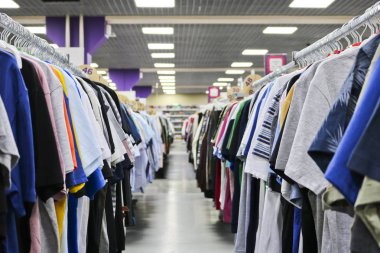 Örme tişört iki satırda asılı mağazada askıları bulanık. Siyah Cuma arifesinde. Bir alışveriş mağazasından tasarım için arka plan.