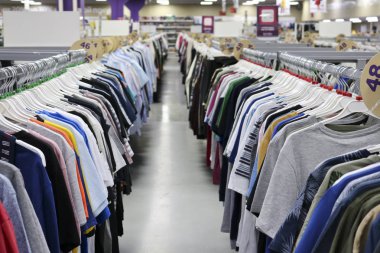 Örme tişört iki satırda asılı mağazada askıları bulanık. Siyah Cuma arifesinde. Bir alışveriş mağazasından tasarım için arka plan.