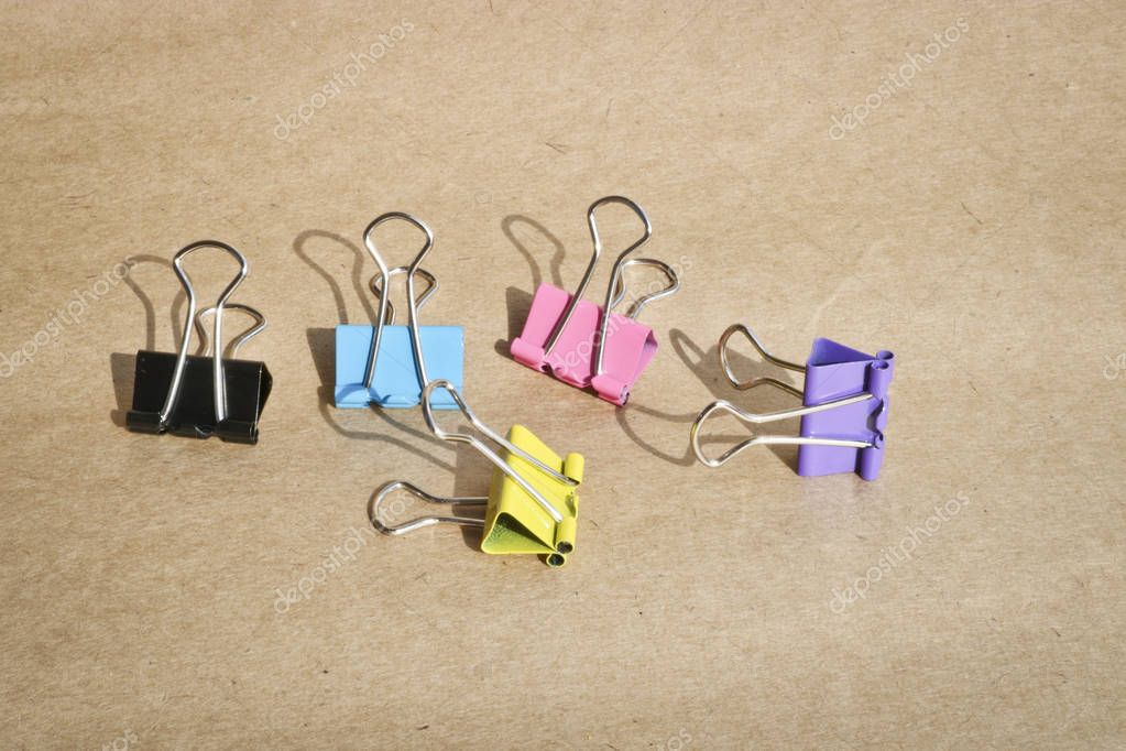 Clips para papel de diferentes colores sobre el fondo de papel kraft