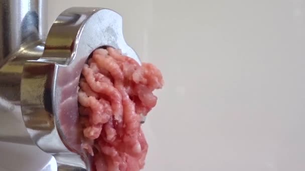 Macinare la carne con un tritacarne elettrico. La carne macinata sale da un tritacarne. Preparazione della carne cruda per la cottura . — Video Stock