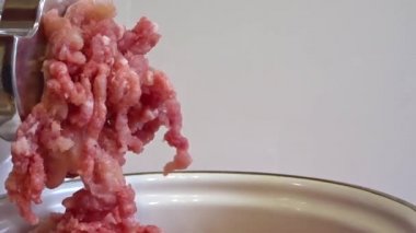 Elektrikli kıyma makinesiile et öğütmek. Kıyma kıyma makinesinden tırmanır. Çiğ etin pişme için hazırlanması.