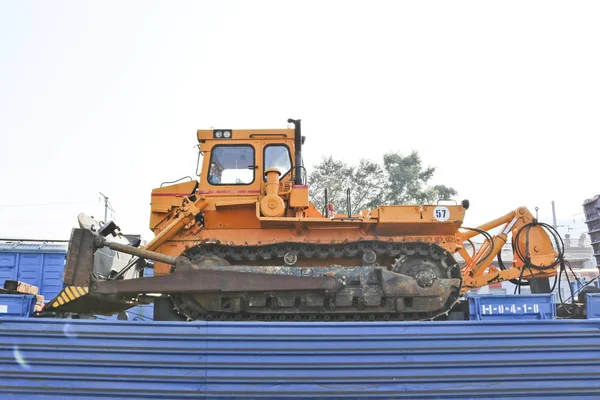 stock image Construction machinery - yellow bulldozer on the platform of a freight railway car. Cargo transit.