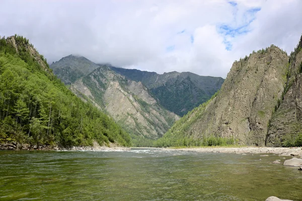 Mountain river on a background of mountains. Siberia, Sayan Mountains, Russia. Summer landscape.