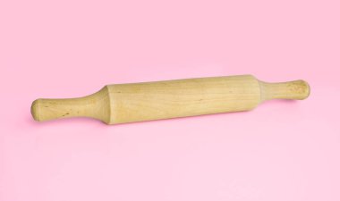 Pembe arka planda hamuru yuvarlamak için mutfak gereçleri. Yemek pişirme araçları.