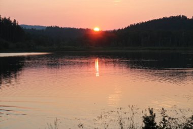 Geniş bir nehirde gün batımı. Pastel günbatımı renkleri. Yaz manzarası.