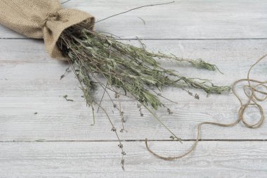 Ahşap masa üzerinde küçük çuval ve hasır plaka üzerinde kurutulmuş lavanta grup. Reklam için şablon.