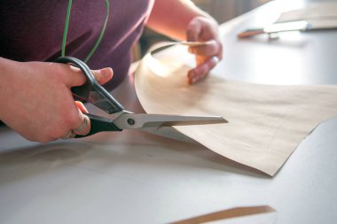 bir makas ile bir terzi elinde yukarıdan görünümü.