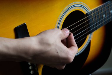 Altı dize gitar çalmak adamın elini