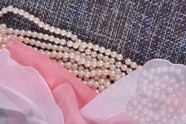 Beads made from artificial pearls on the rude beautiful fabric — Stock Photo, Image